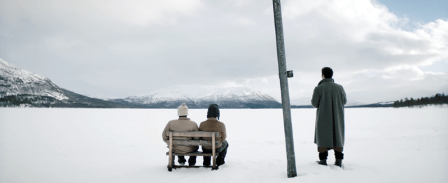 A Happy Day film still of figures sitting on a frozen landscape
