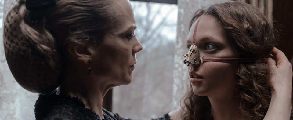 A film still of a woman being strapped into a mask. Photo by Marcel Zyskind